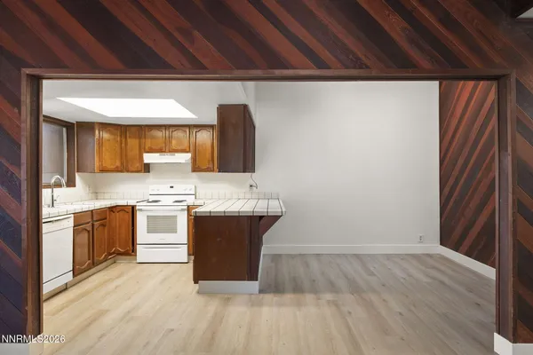 a room with granite countertop a sink and a stove top oven