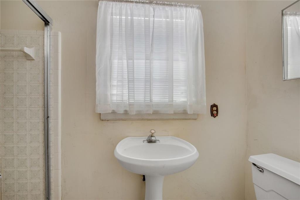 1955 Flat Shoals Road Southeast Conyers, GA 30013 - Photo 21 of 56 a bathroom with a sink a mirror and a toilet