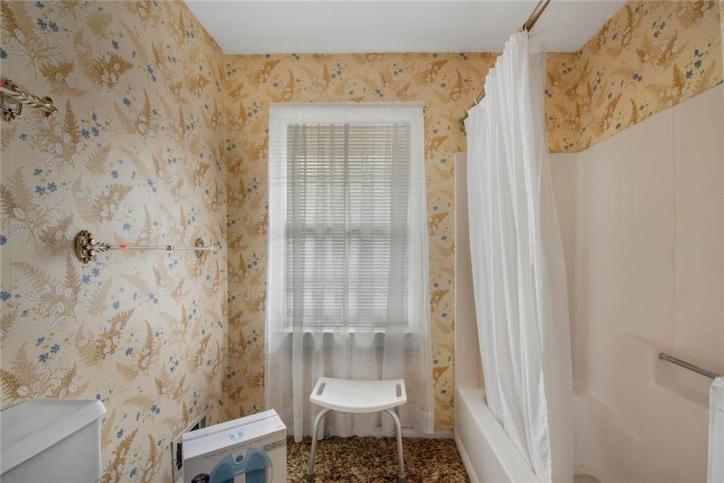 1955 Flat Shoals Road Southeast Conyers, GA 30013 - Photo 30 of 56 a bathroom with a toilet and a shower curtain