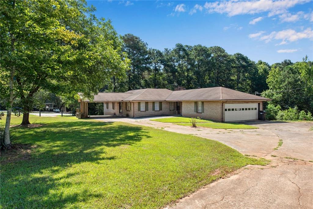 1955 Flat Shoals Road Southeast Conyers, GA 30013 - Photo 3 of 56 a house view with a sitting space and garden