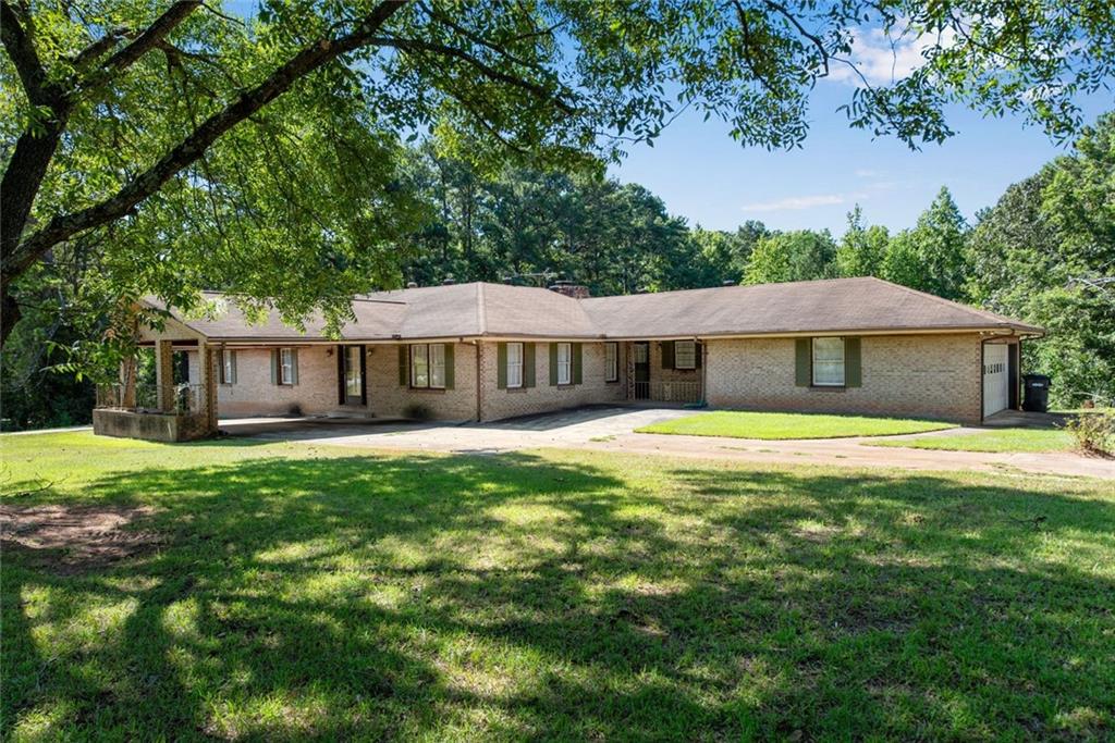1955 Flat Shoals Road Southeast Conyers, GA 30013 - Photo 4 of 56 a front view of a house with yard and porch