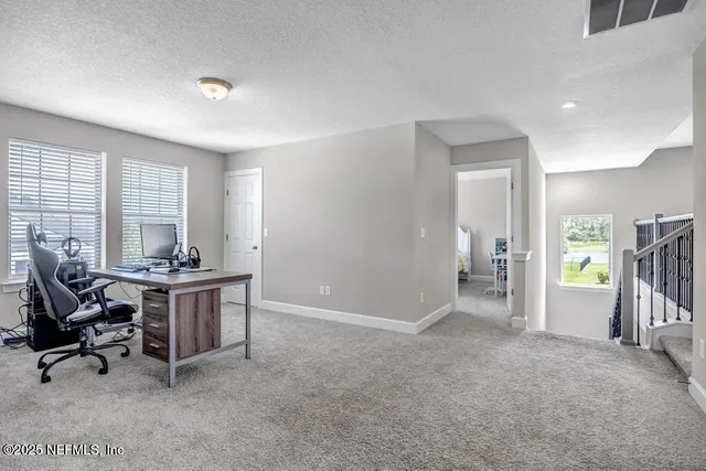 a view of a workspace with furniture and a window