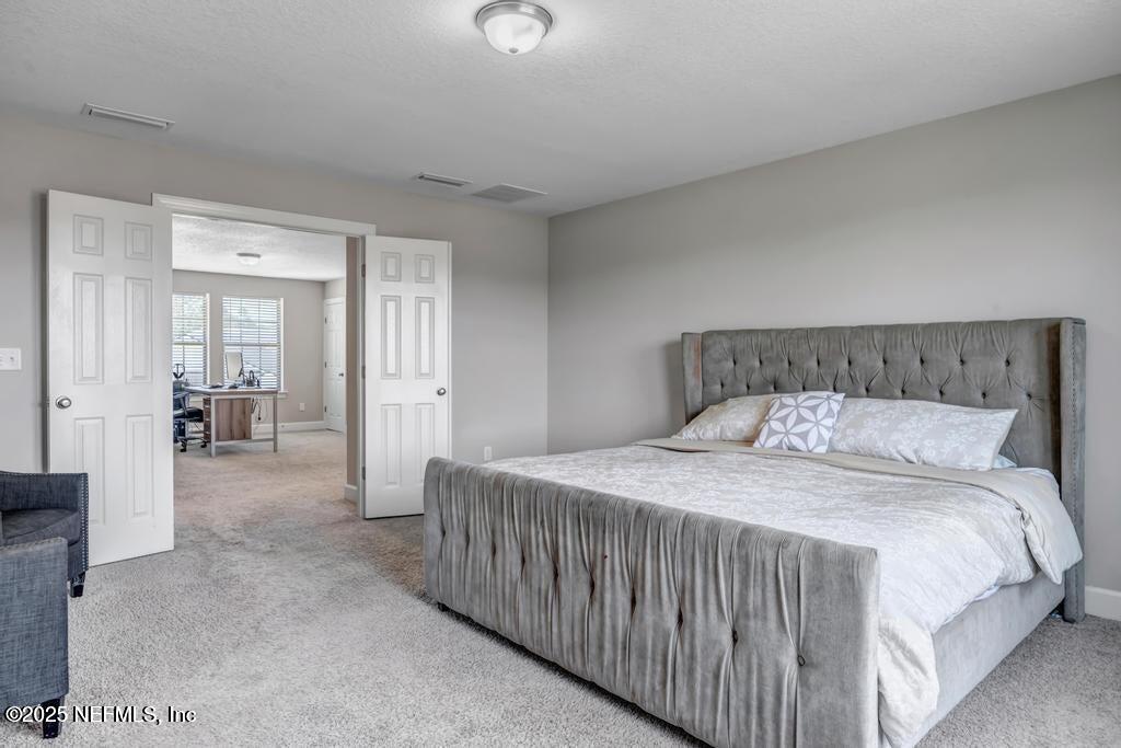 23 Catesby Lane St. Augustine, FL 32095 - Photo 16 of 31 a bedroom with a balcony a bed and a view of living room