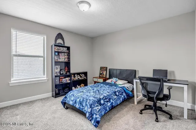 a bedroom with a bed a table and a bookshelf