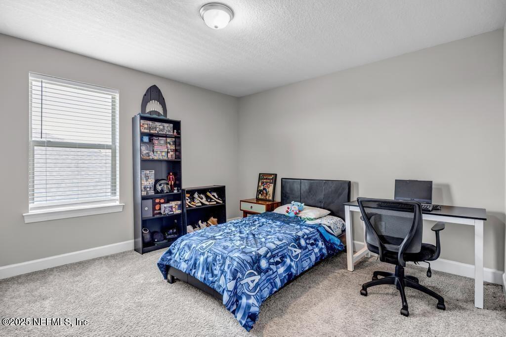 23 Catesby Lane St. Augustine, FL 32095 - Photo 21 of 31 a bedroom with a bed a table and a bookshelf