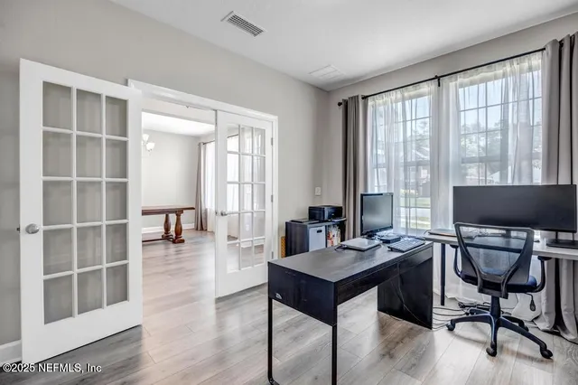 a view of a workspace with furniture and a window