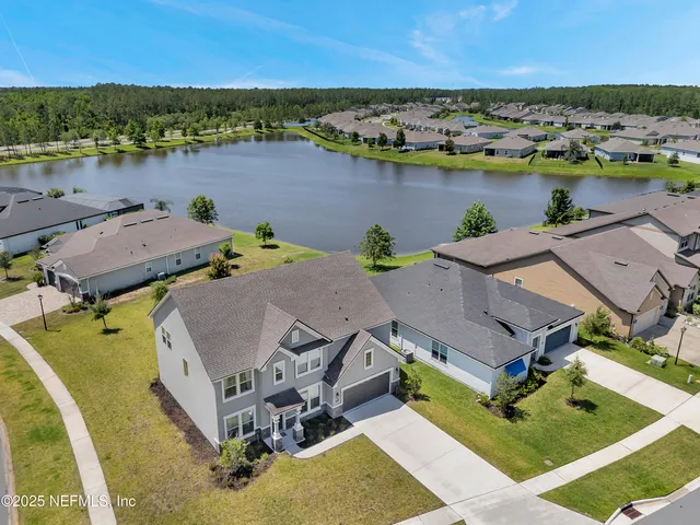an aerial view of a house with outdoor space and lake view
