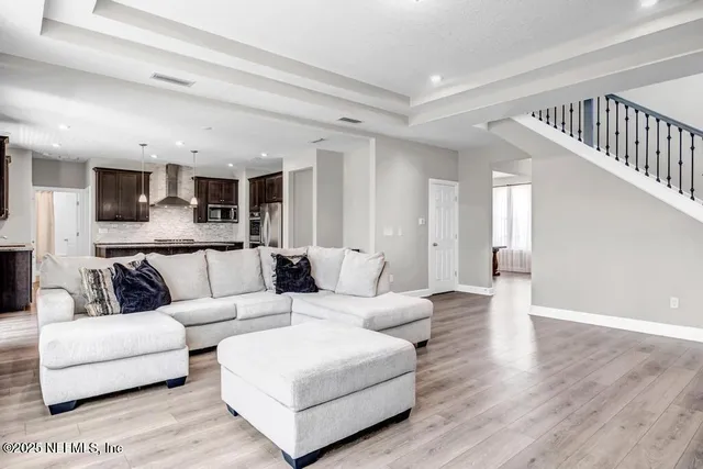 a living room with furniture and a wooden floor