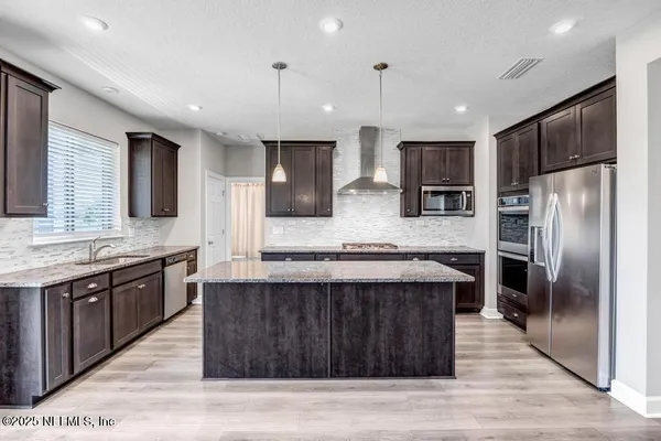 a kitchen with stainless steel appliances granite countertop wooden cabinets and sink