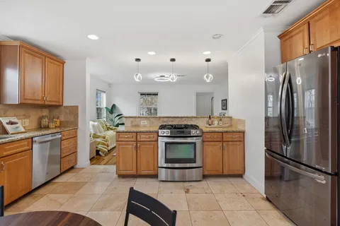 a kitchen with stainless steel appliances granite countertop a sink stove and cabinets