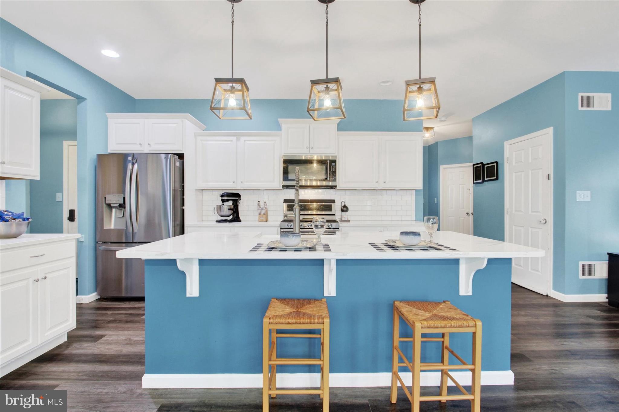 155 Sunbury Way Red Lion, PA 17356 - Photo 6 of 36 a kitchen with kitchen island stainless steel appliances a table chairs sink and wooden floor