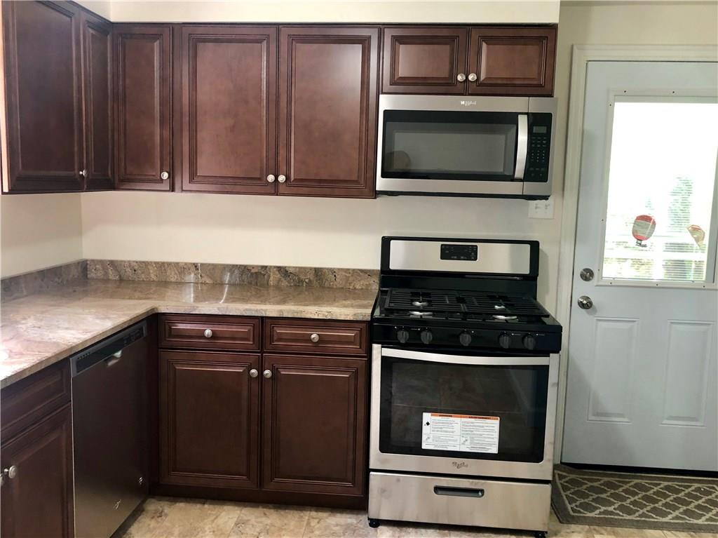 1040 5th Street Baden, PA 15005 - Photo 8 of 25 a kitchen with granite countertop wood cabinets and stainless steel appliances