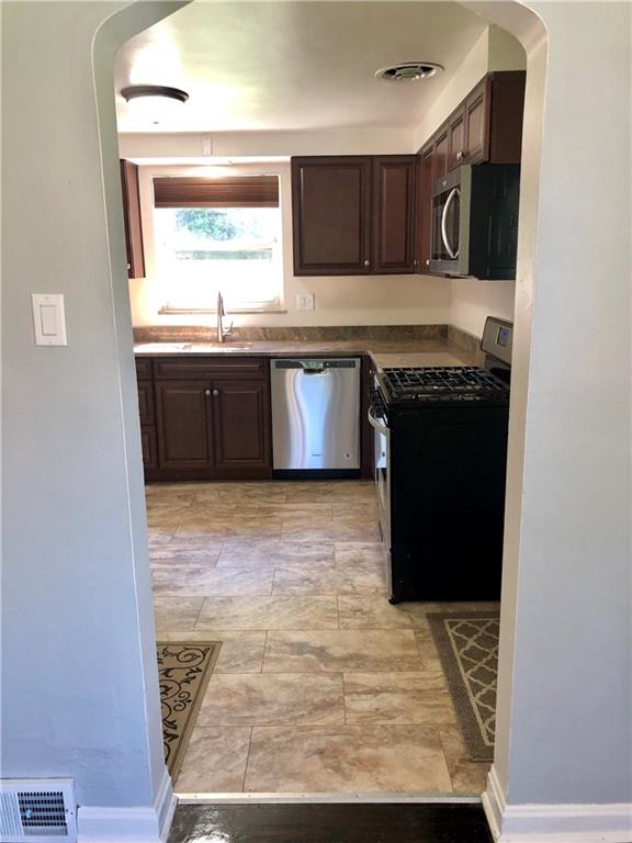 1040 5th Street Baden, PA 15005 - Photo 10 of 25 a kitchen with stainless steel appliances granite countertop a stove a sink and a refrigerator