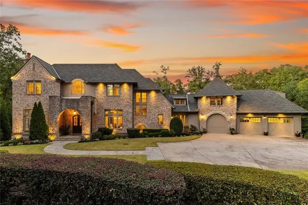 a view of a big house with a big yard and large trees