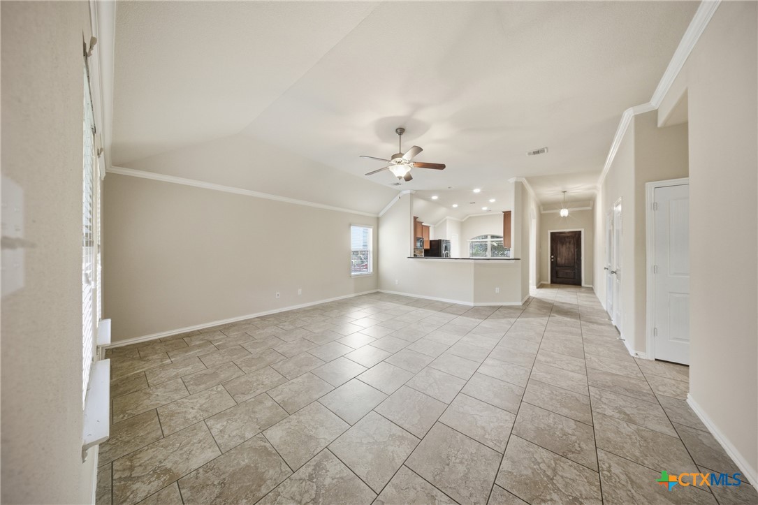 728 Olaf Drive Temple, TX 76504 - Photo 17 of 26 an empty room with kitchen and chandelier fan