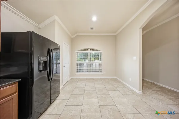 an empty room with windows and chandelier fan