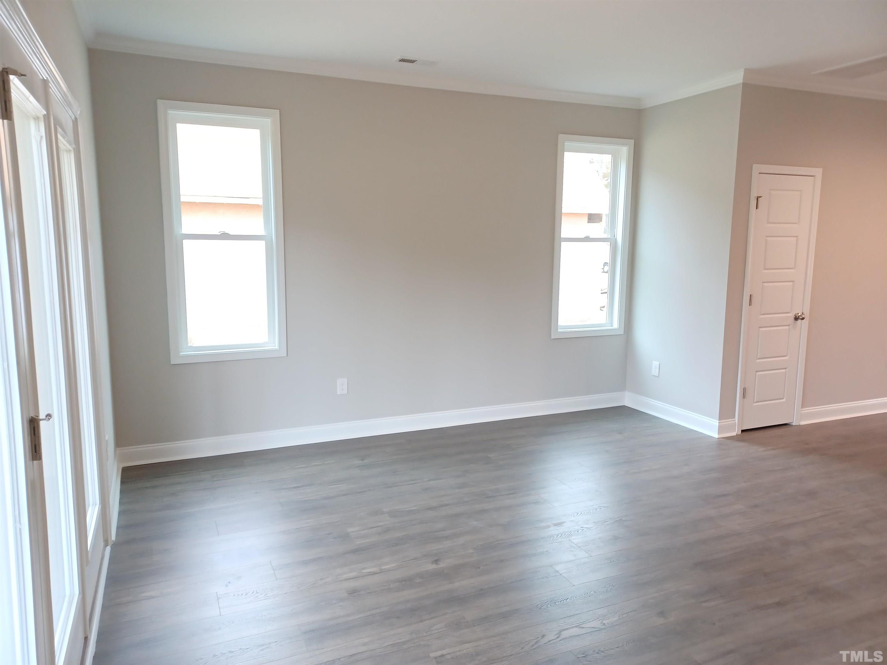 184 Howards Crossing Drive Wendell, NC 27591 - Photo 4 of 27 an empty room with wooden floor and windows