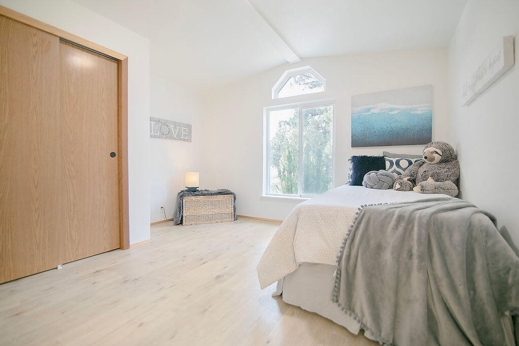 17231 Downey Road Bend, OR 97707 - Photo 25 of 40 a bedroom with a bed and a chandelier