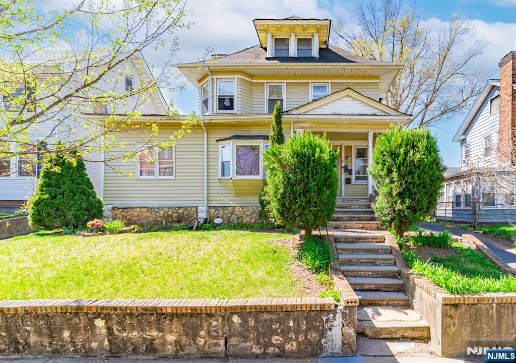 90 Renner Avenue Newark, NJ 07112 - Photo 1 of 25 a view of a brick house with a yard plants and large tree