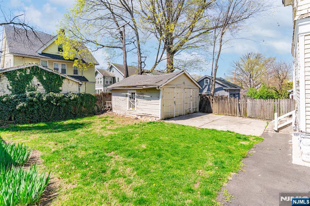 90 Renner Avenue Newark, NJ 07112 - Photo 24 of 25 a view of a white house with a small yard and large tree