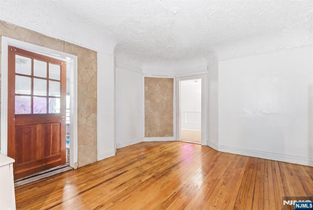 90 Renner Avenue Newark, NJ 07112 - Photo 4 of 25 a view of an empty room with wooden floor and a window
