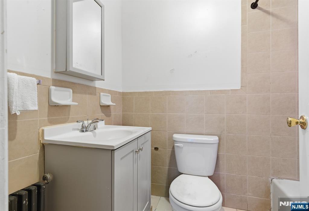 90 Renner Avenue Newark, NJ 07112 - Photo 6 of 25 a bathroom with a toilet sink and mirror