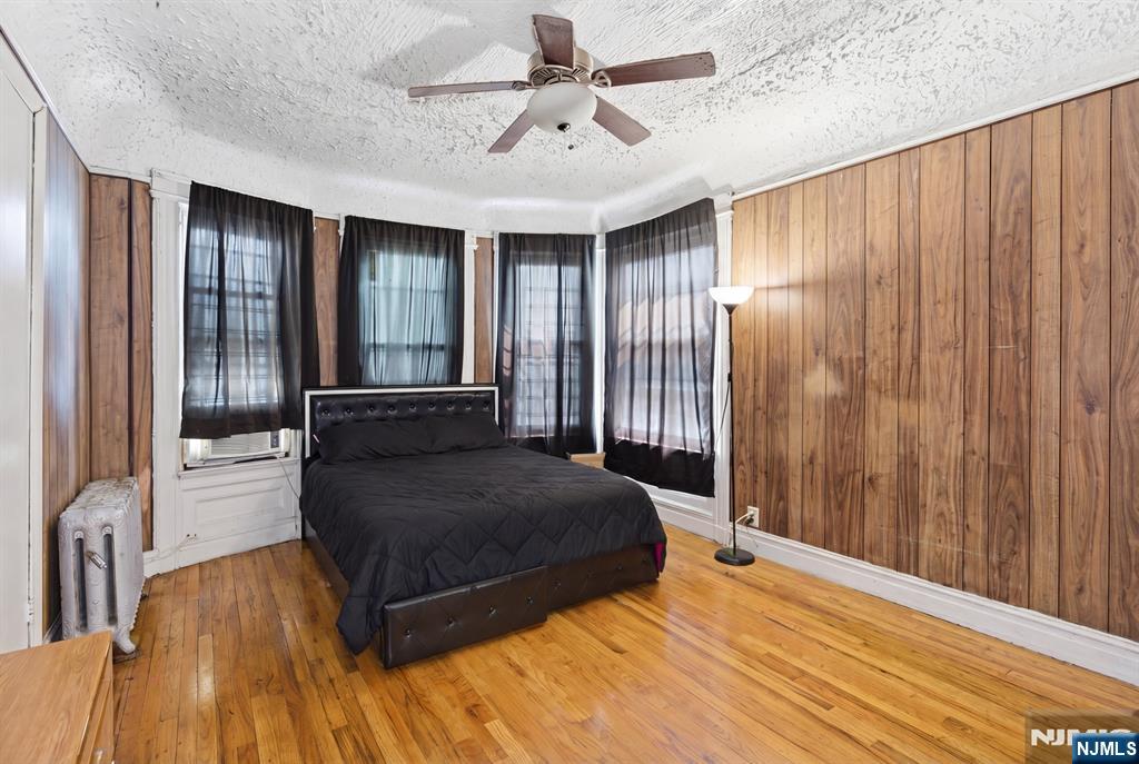 90 Renner Avenue Newark, NJ 07112 - Photo 9 of 25 a spacious bedroom with a bed and a chandelier