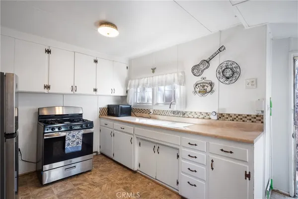a kitchen with granite countertop white cabinets and stainless steel appliances
