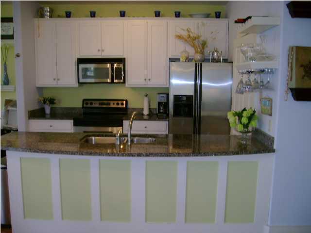 1594 Co Road North Santa Rosa Beach, FL 32459 - Photo 4 of 11 a kitchen with stainless steel appliances granite countertop a refrigerator a stove and a sink with wooden floor