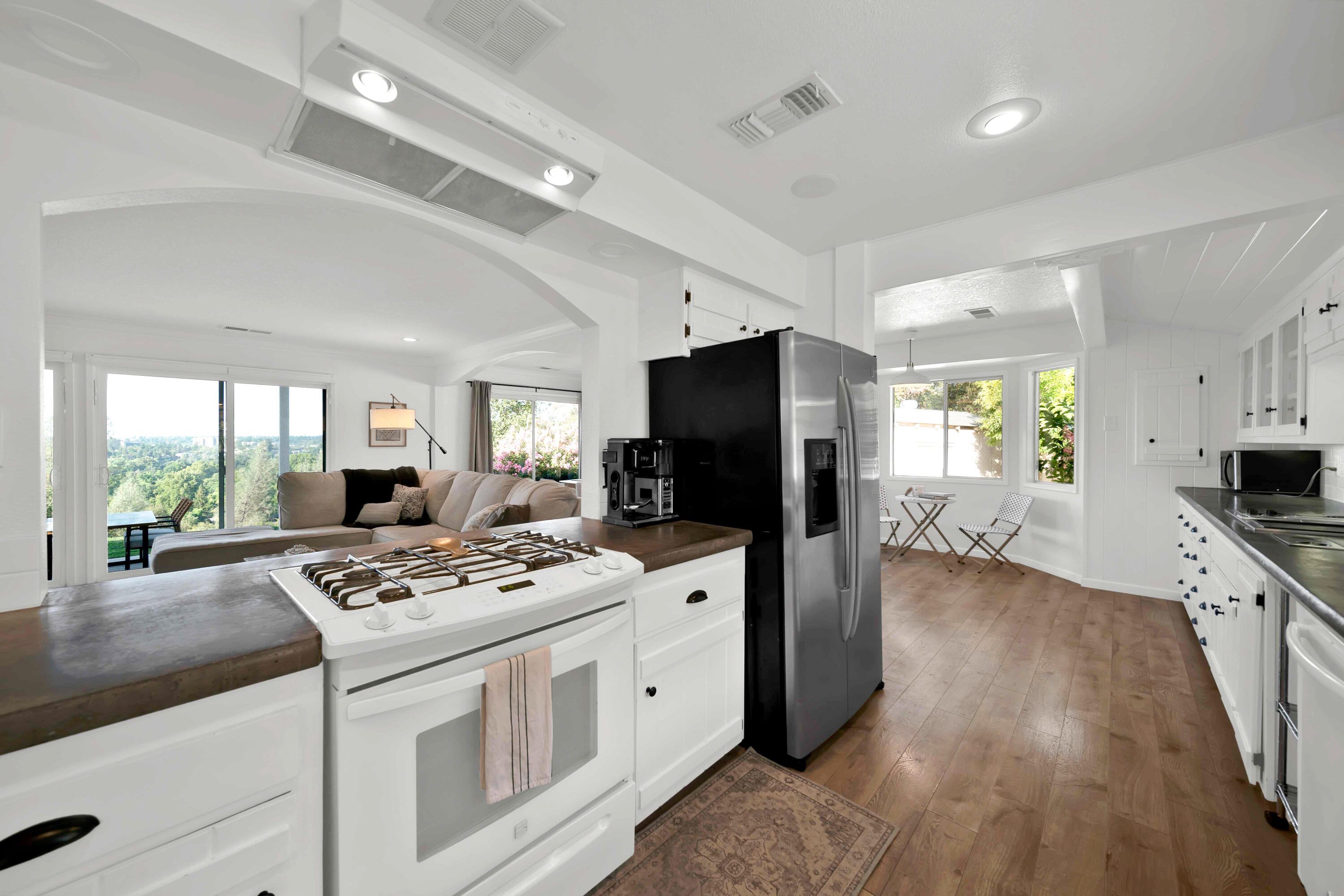 1705 Barbara Road Redding, CA 96003 - Photo 40 of 103 a kitchen with stainless steel appliances kitchen island granite countertop a stove refrigerator a sink dishwasher and a stove with wooden floor