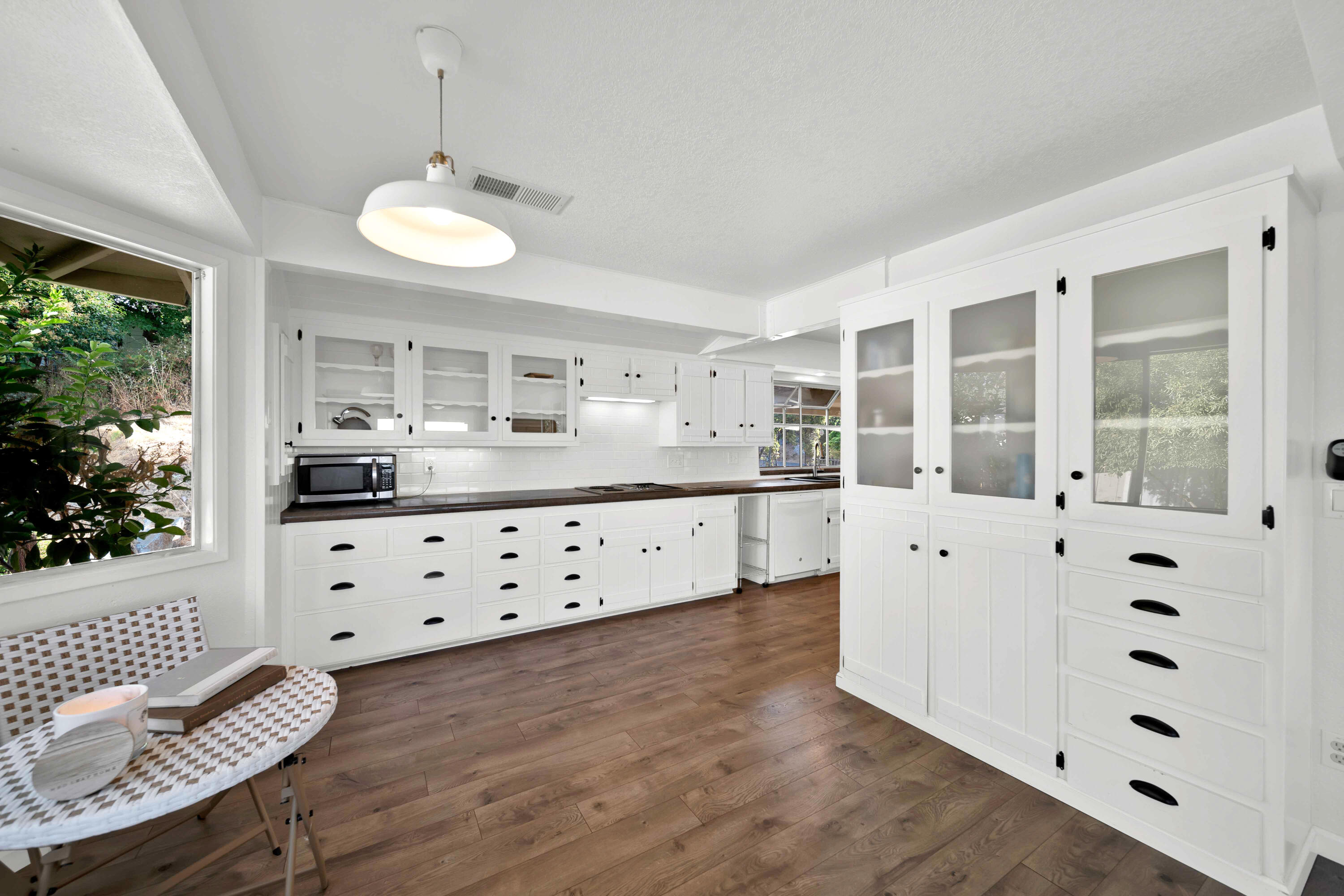 1705 Barbara Road Redding, CA 96003 - Photo 49 of 103 a kitchen with cabinets a sink a window and chairs