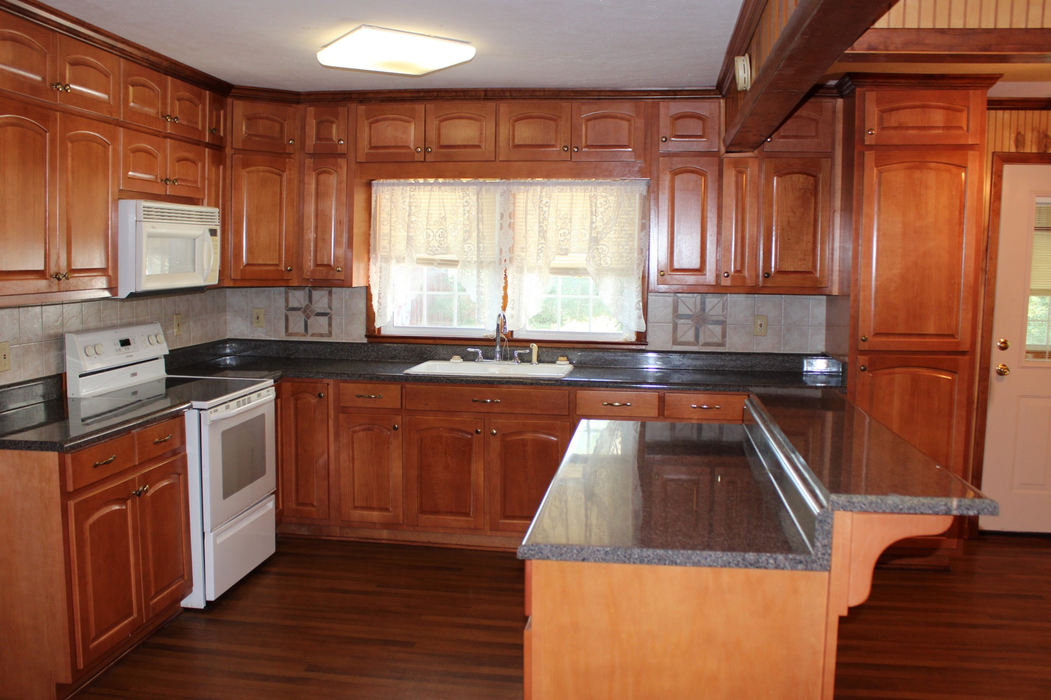 512 Limestone Road Elora, TN 37328 - Photo 8 of 44 a kitchen with granite countertop wooden cabinets a sink and a stove