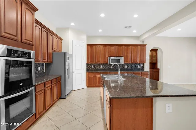 a kitchen with stainless steel appliances granite countertop a stove a sink and a microwave