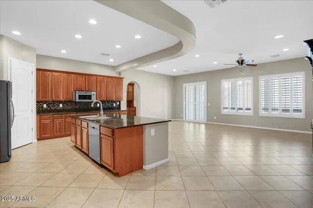 a kitchen with stainless steel appliances granite countertop a stove a sink a microwave and a refrigerator