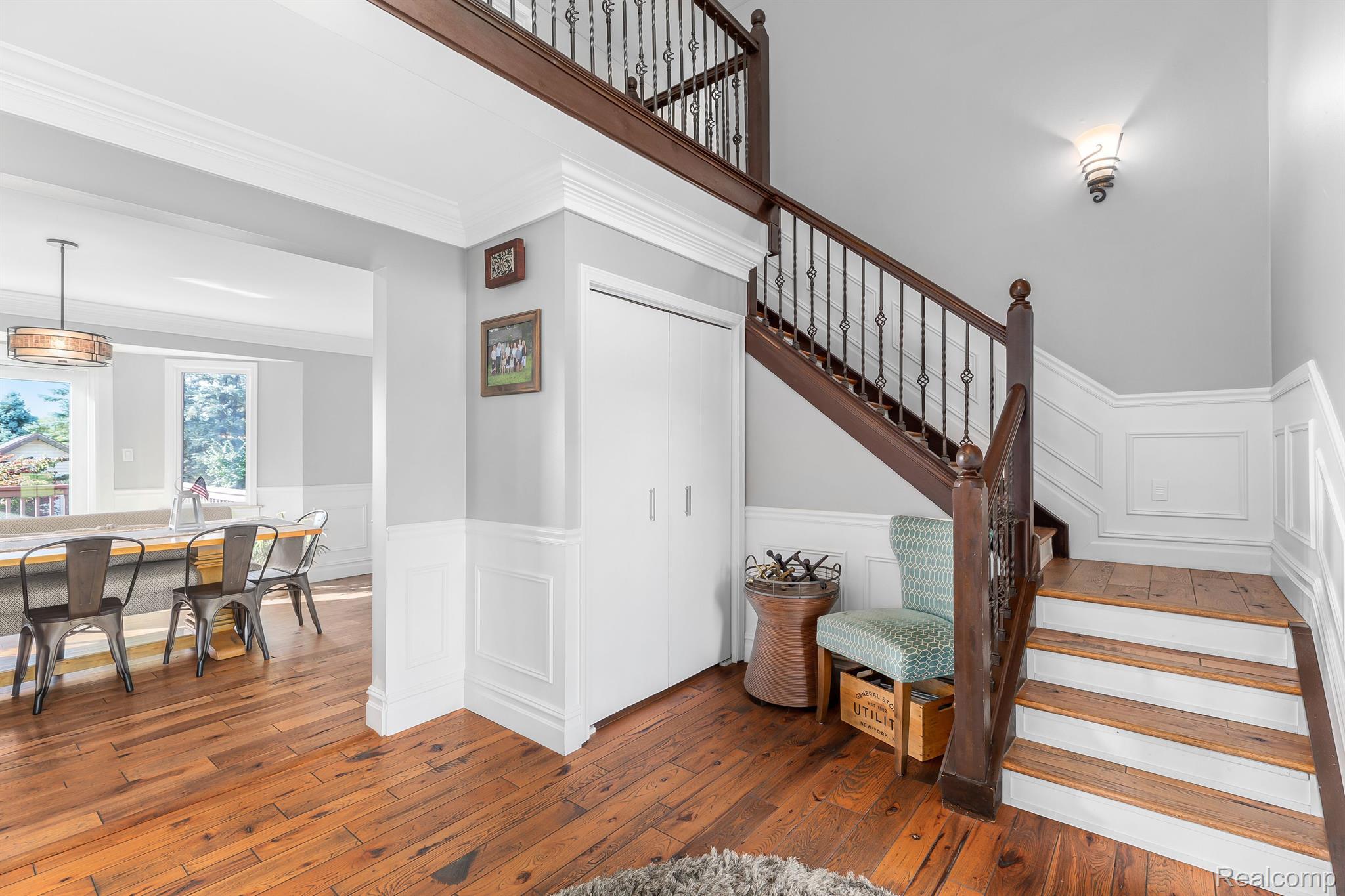 Staircase with iron spindles and wainscoting.
