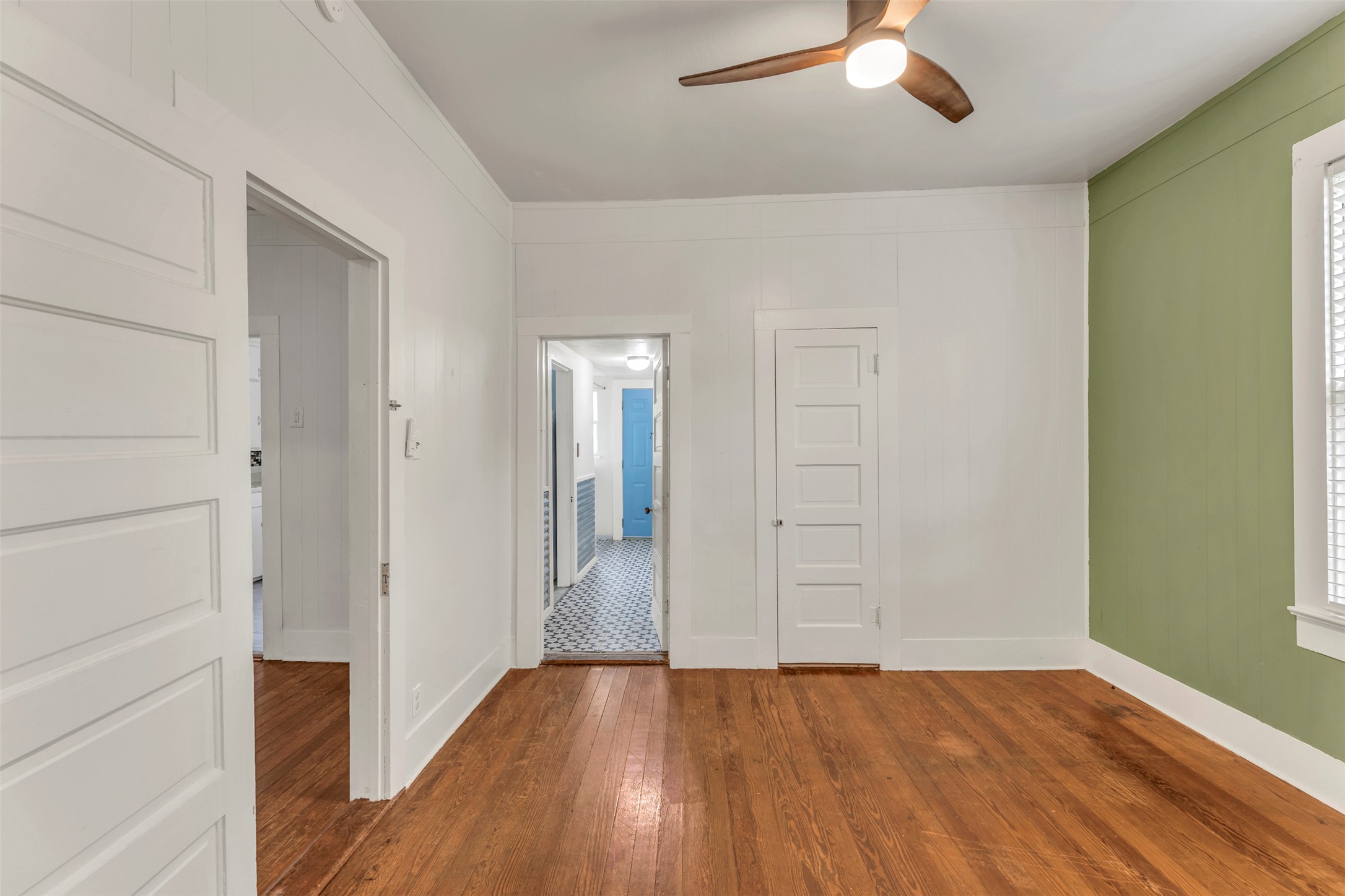 1002 Washburn Street Taylor, TX 76574 - Photo 22 of 29 This room features rich hardwood flooring, a ceiling fan with integrated lighting, and a window with blinds