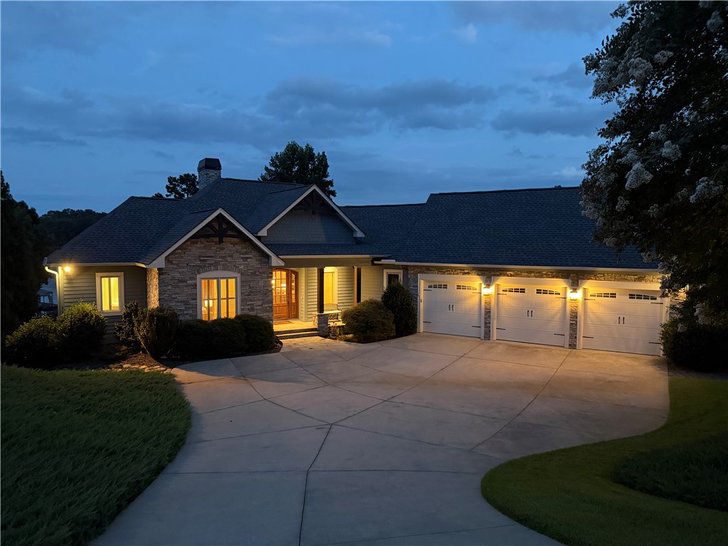 357 Stardust Lane Seneca, SC 29672 - Photo 47 of 50 An expansive concrete driveway leads to a three-car garage and stone-accented facade.