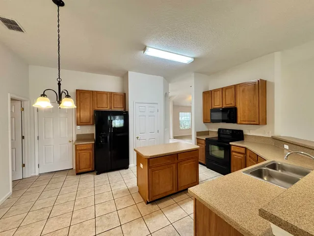 a kitchen with a stove a sink and a refrigerator