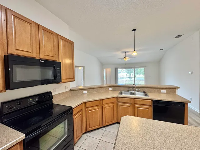 a kitchen with stainless steel appliances granite countertop a sink stove and microwave