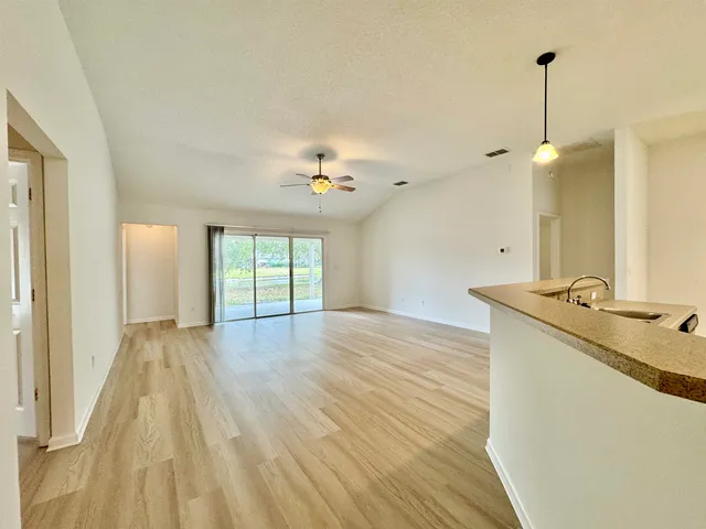 a view of a kitchen with wooden floor and a sink