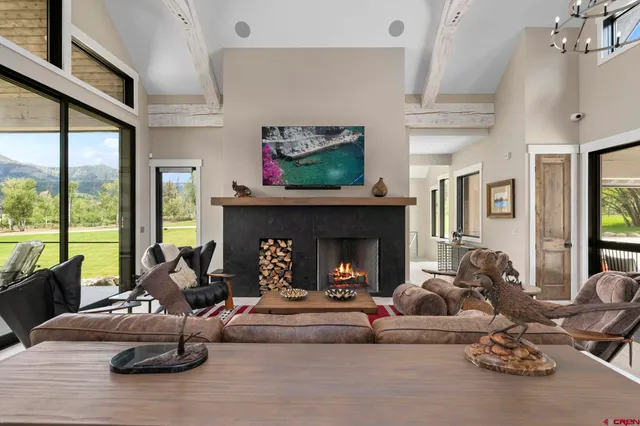a living room with furniture large window and flat screen tv