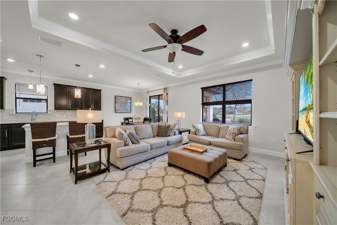 19918 Beverly Park Road Estero, FL 33928 - Photo 12 of 46 a living room with furniture and a flat screen tv with kitchen view