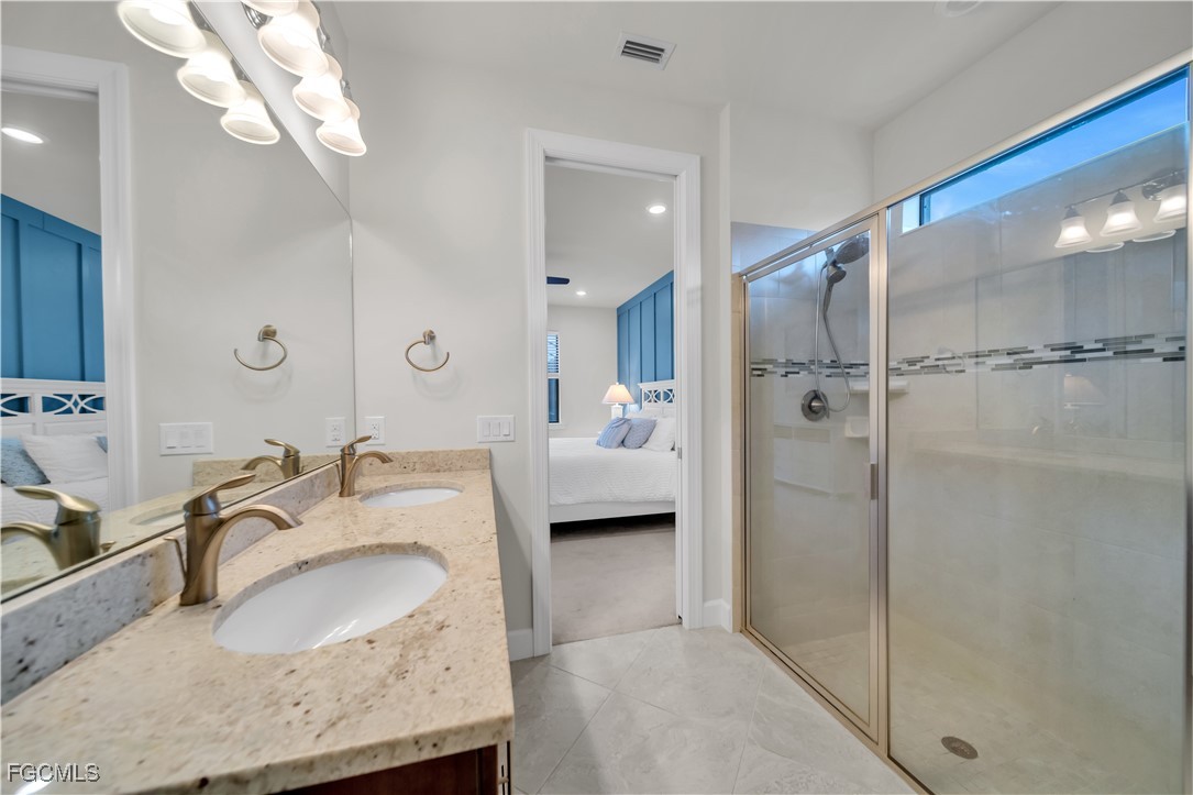 19918 Beverly Park Road Estero, FL 33928 - Photo 15 of 46 a bathroom with a granite countertop sink mirror and shower