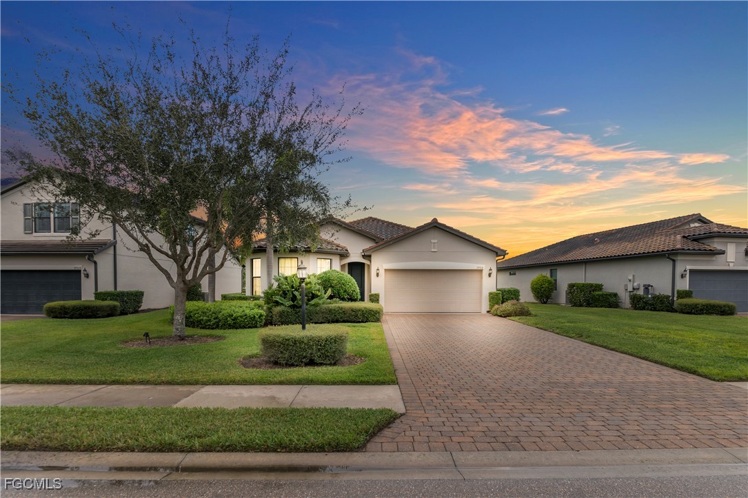 19918 Beverly Park Road Estero, FL 33928 - Photo 29 of 46 a front view of a house with a yard and garage