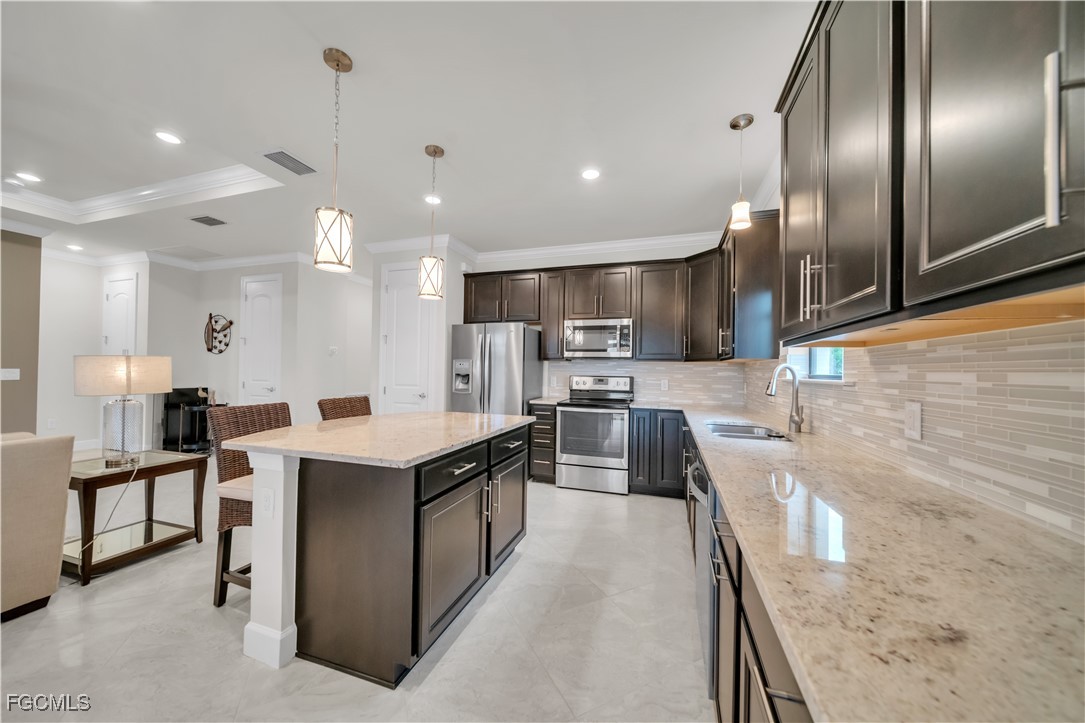 19918 Beverly Park Road Estero, FL 33928 - Photo 9 of 46 a kitchen with stainless steel appliances granite countertop a sink a stove and a refrigerator