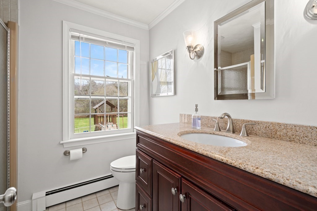 1091 Bay Road Hamilton, MA 01982 - Photo 21 of 40 a bathroom with a granite countertop sink a toilet and a window