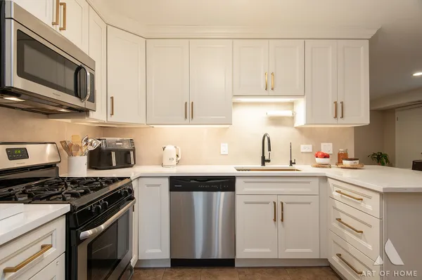 a kitchen with granite countertop white cabinets and appliances