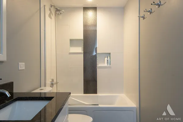a bathroom with a tub shower sink and vanity