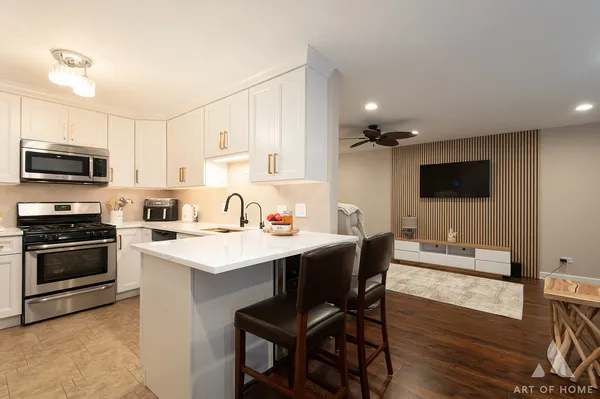 a kitchen with a sink stainless steel appliances and white cabinets
