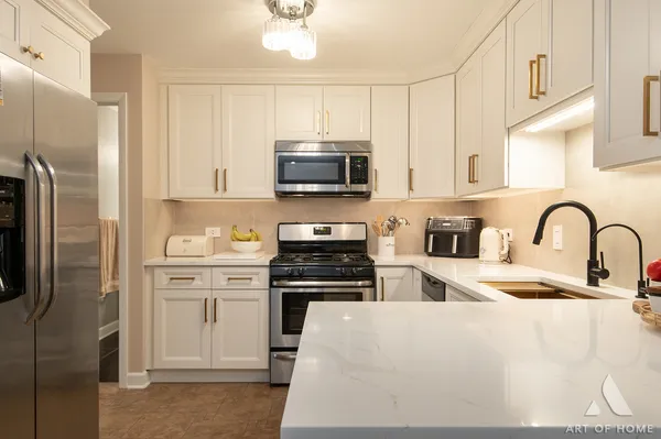 a kitchen with stainless steel appliances granite countertop a stove a sink dishwasher a refrigerator and a stove